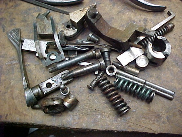 A pile of the parts as they came from the gun.  You can see the main springs are kind of a frosted metal finish with each of them having a different colored effect to them.<br />Nice strong springs with squared ends. They certainly do swat those hammers!<br />A bit of surface rust on the parts with all the dirt but it all cleaned up.